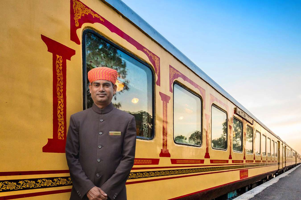 A staff member on the Palace on Wheels luxury train, wearing traditional railway attire