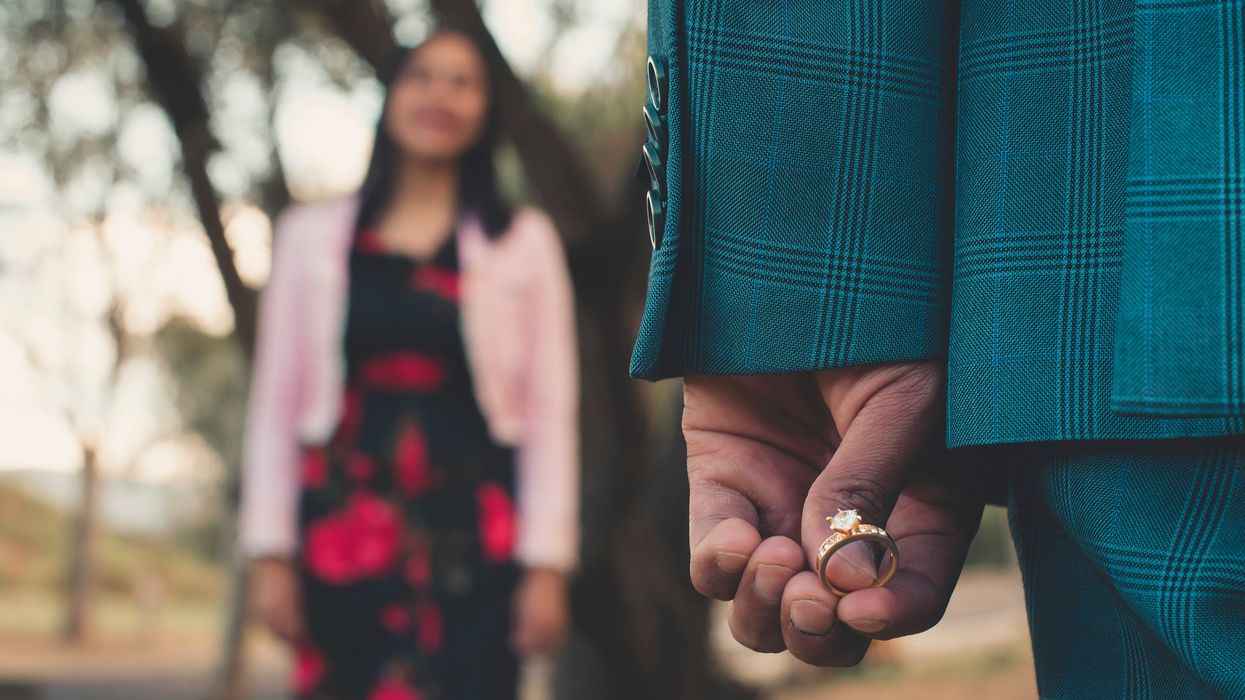 A stock image of a man holding an engagement ring