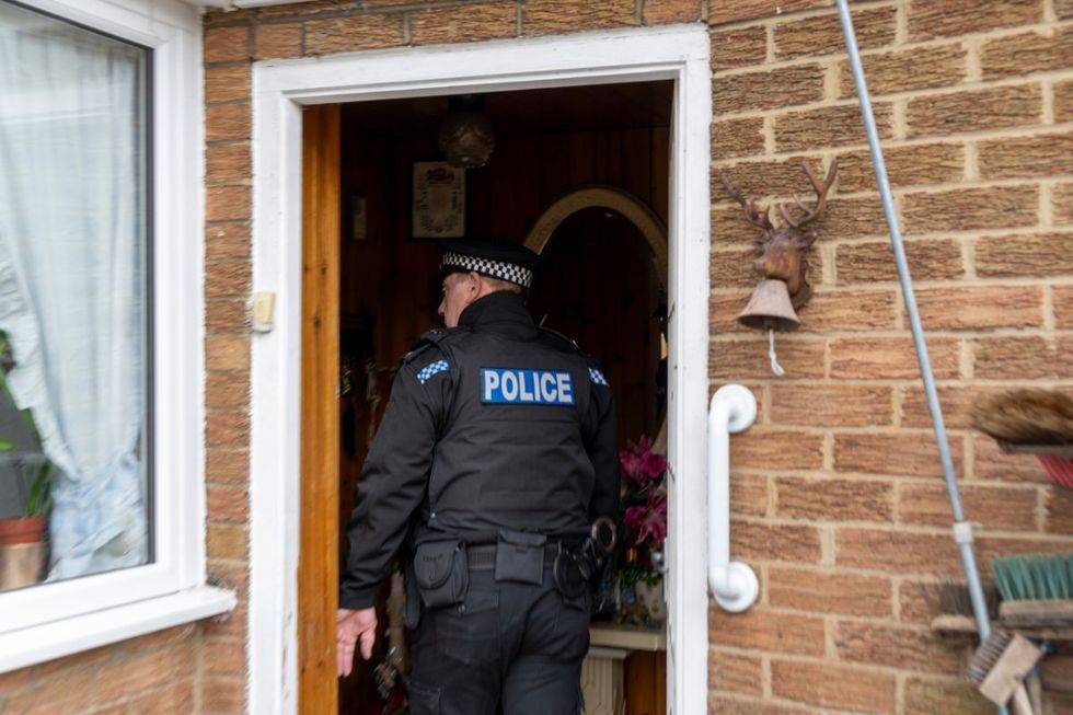 A stock image of a police officer entering a home