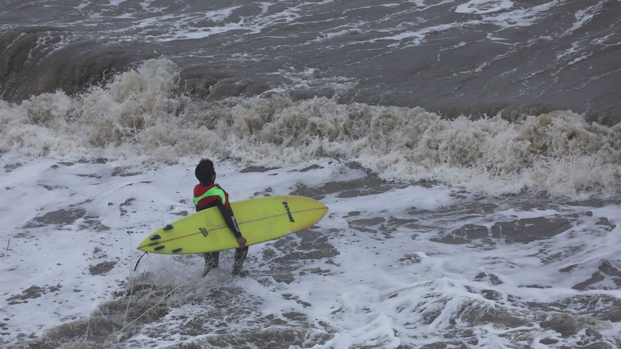 A surfer enters the water at the Mavericks Beach near the Half Moon Bay, California