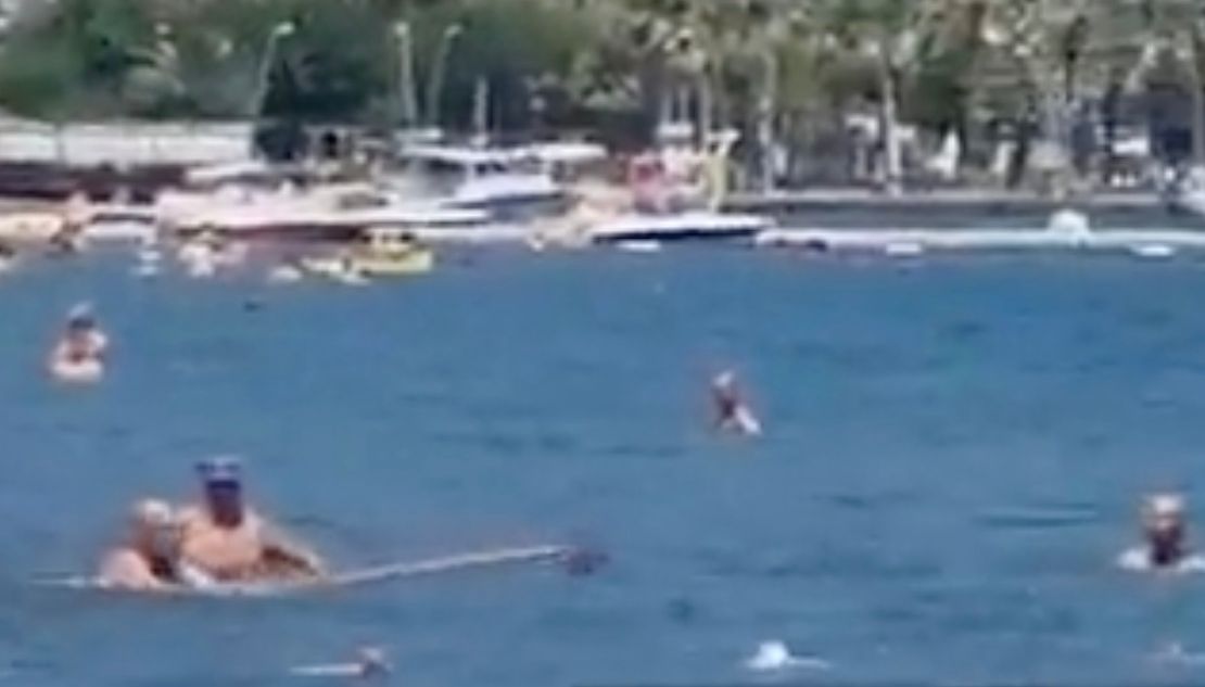 A swimmer used a mop to move a 'shark' away