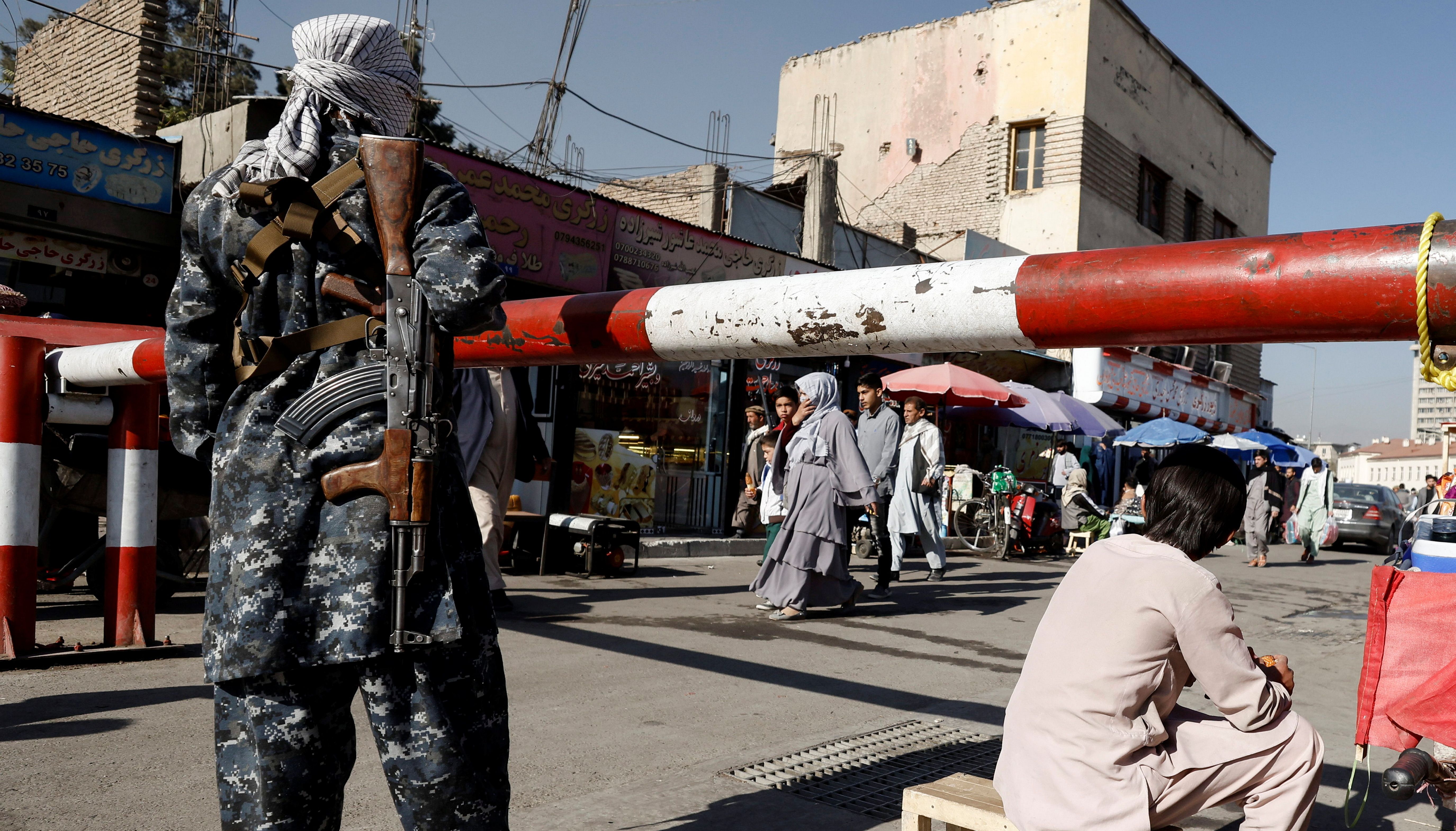 A Taliban fighter stands guard at the market in Kabul, Afghanistan.