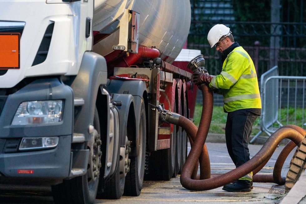 A tanker driver makes a fuel delivery at a petrol station in south London