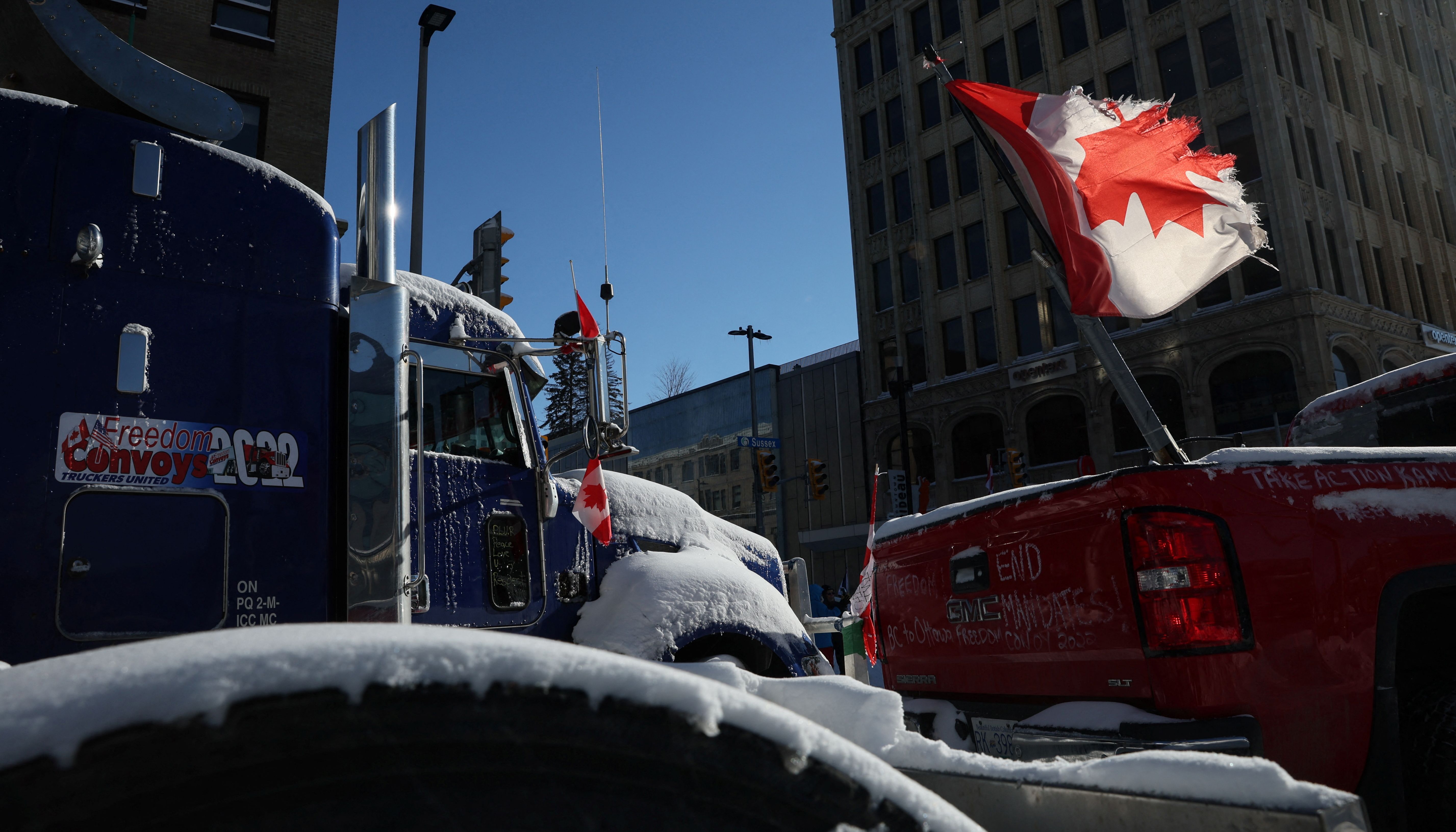 A tattered flag of Canada flies from the back of a vehicle, as truckers and their supporters continue to protest against Covid vaccine mandates, in Ottawa, Canada