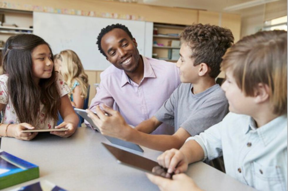 A teacher from an ethnic minority talking to a pupil.