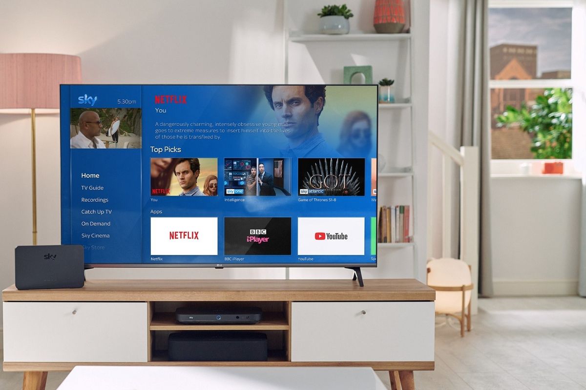a television on a cabinet shows the Sky TV main menu with Netflix shows included in the recommendations 