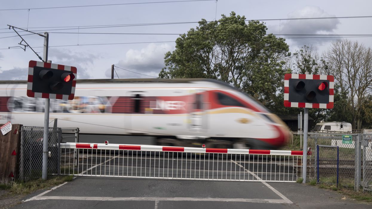 A train passes by a level crossing in Balderton, near Newark-on-Trent