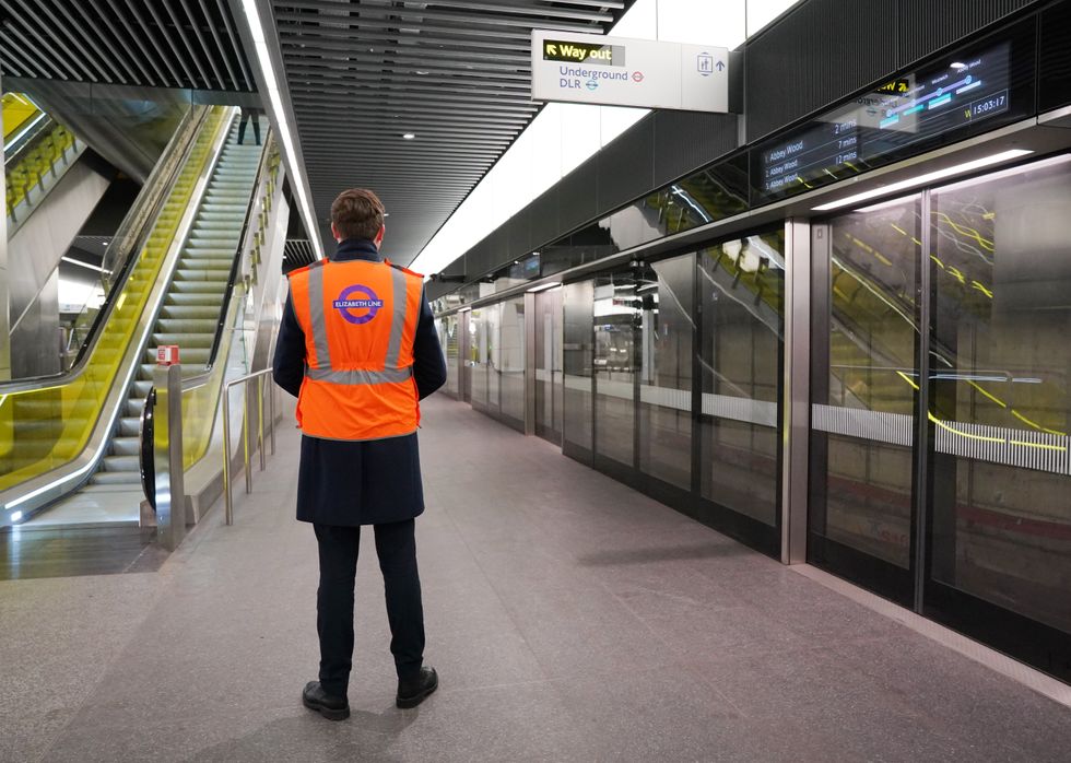 A Transport for London employee stands on the platform at the Canary Wharf Elizabeth Line Station