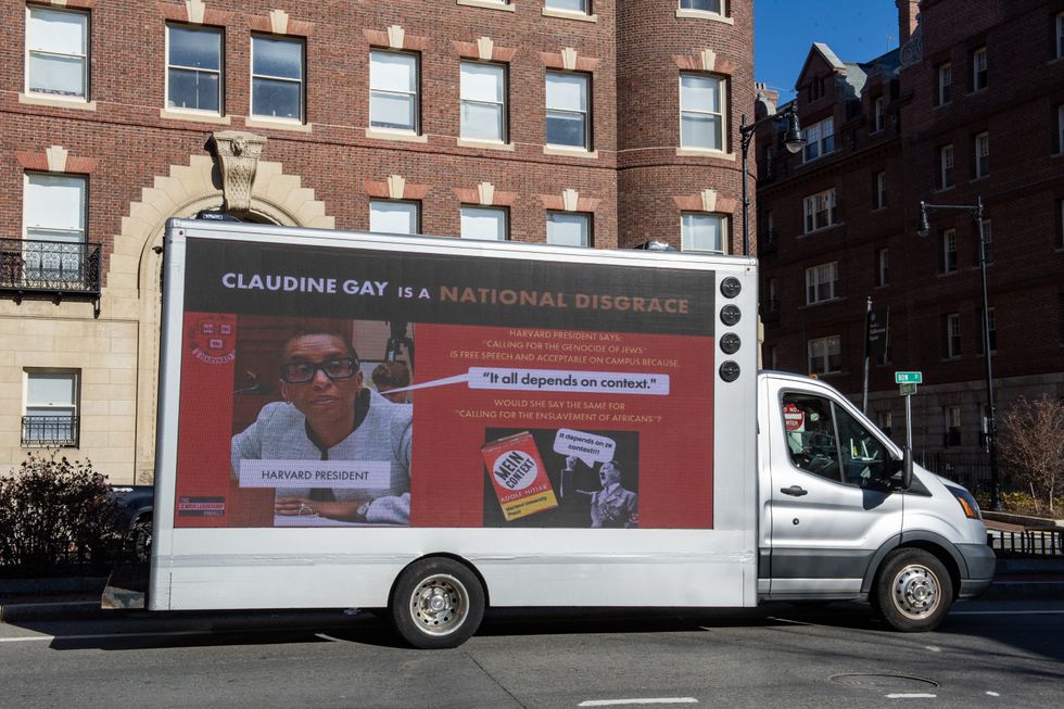 A truck calling the president of Harvard a disgrace drives around Harvard University in Cambridge, Massachusetts