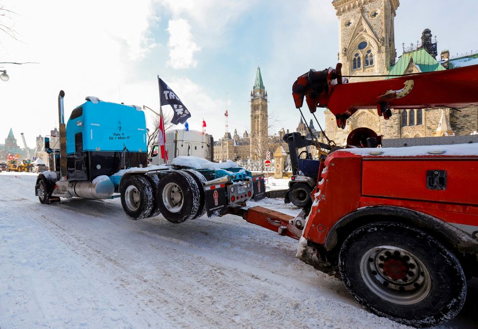 A truck is towed from in front of Parliament Hill as Canadian police work to restore normality to the capital after trucks and demonstrators occupied the downtown core for more than three weeks to protest against pandemic restrictions in Ottawa, Canada