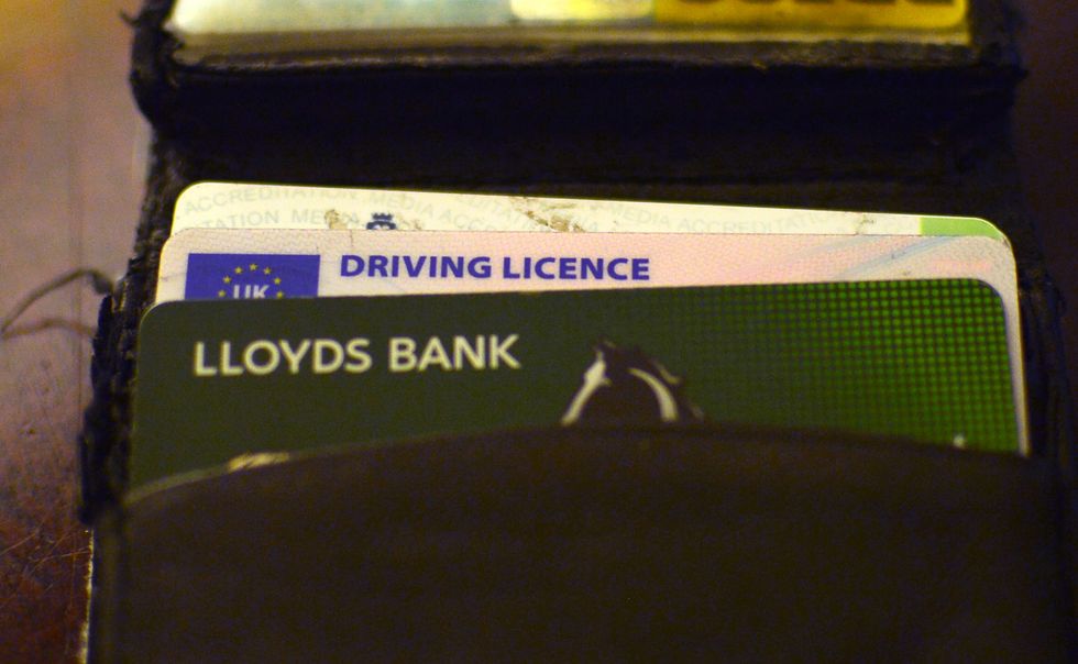 A UK driving licence placed in a wallet, London.