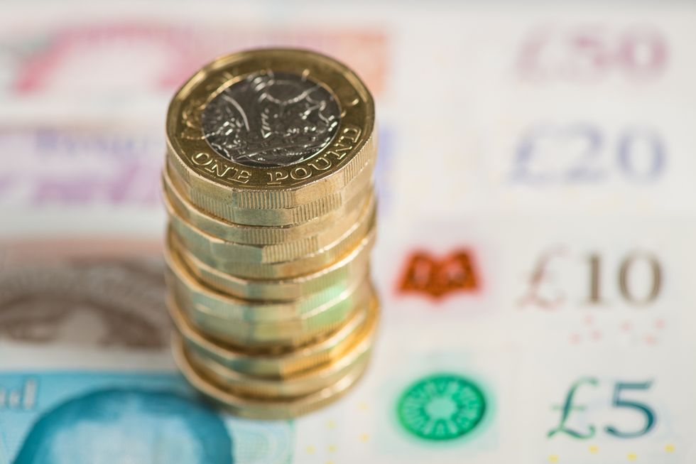 A UK five pound, ten pound, twenty pound and fifty pound notes with one pound coins