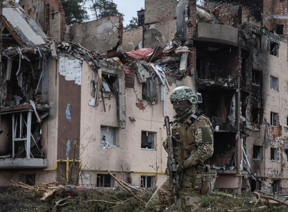 A Ukrainian serviceman is seen near buildings destroyed by Russian shelling, as Russia's attack on Ukraine continues, in the town of Irpin outside of Kyiv, Ukraine April 28, 2022. REUTERS/Gleb Garanich