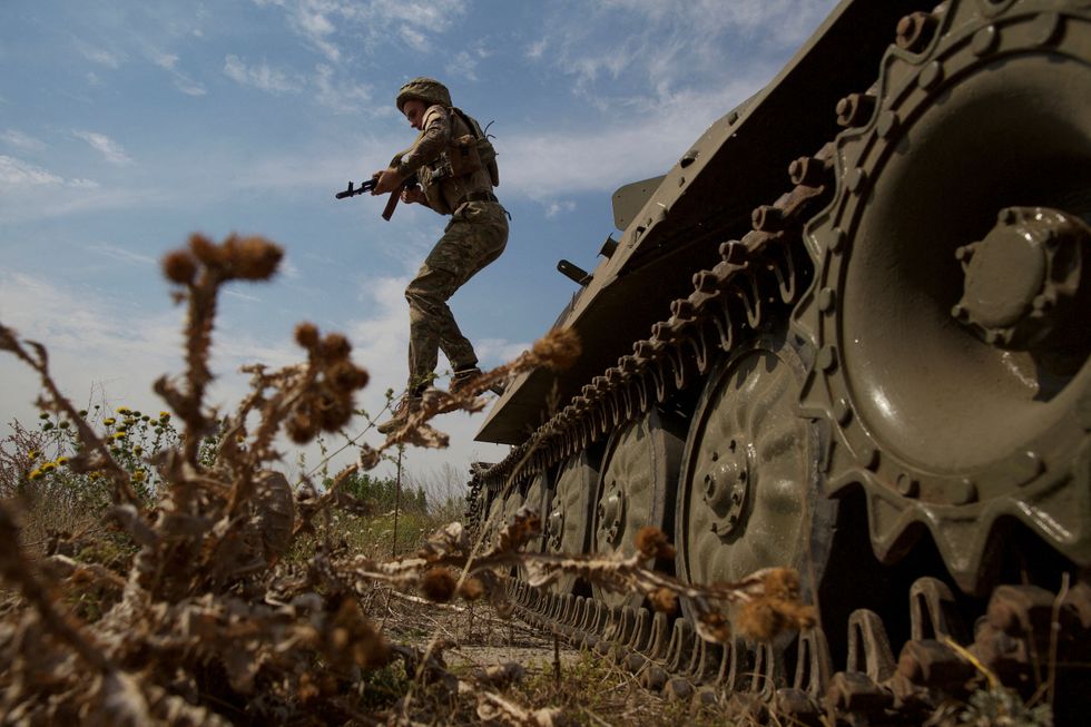 A Ukrainian serviceman jumps from a military vehicle near a frontline in Mykolaiv region, as Russia's attack on Ukraine continues, Ukraine August 10, 2022. REUTERS/Anna Kudriavtseva TPX IMAGES OF THE DAY
