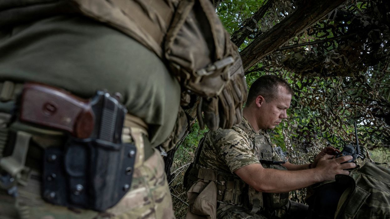A Ukrainian serviceman operates an FPV drone from his positions at a front line, as Russia's attack on Ukraine continues, near the village of Robotyne