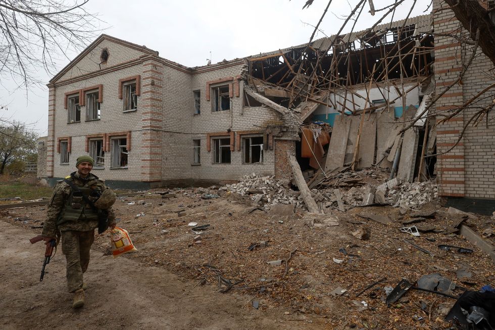 A Ukrainian serviceman walks past a building of a kindergarten damaged during a Russian missile attack in the village of Novooleksandrivka, in Kherson region, Ukraine November 9, 2022. REUTERS/Valentyn Ogirenko