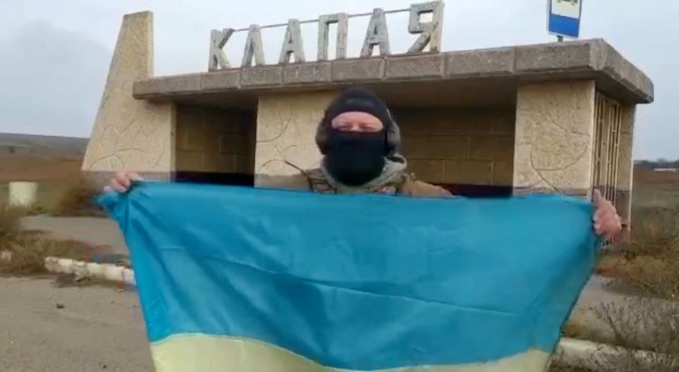 A Ukrainian soldier waves the national flag in Klapaya village, Kherson Region, Ukraine in this screen grab obtained from a video released on November 11, 2022Video obtained by Reuters/Handout via REUTERS  THIS IMAGE HAS BEEN SUPPLIED BY A THIRD PARTY. NO RESALES. NO ARCHIVES
