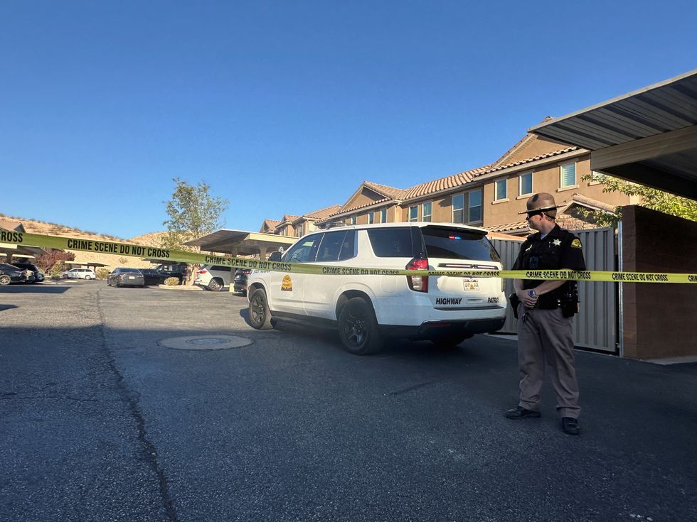 A Utah State Police officer stands guard behind tape during a crime scene investigation by FBI and state forensic agents at an apartment complex where Tyler Robinson lived