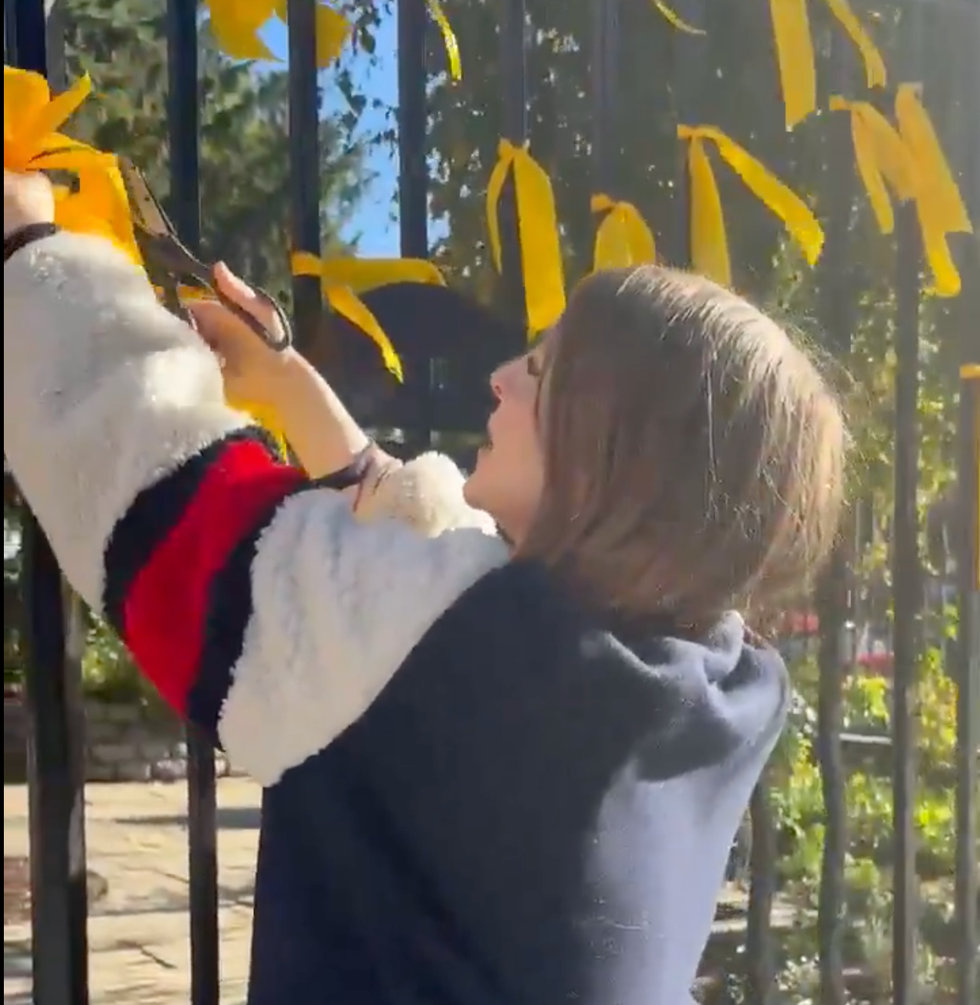 A video shows the moment a woman cut down memorial ribbons with scissors