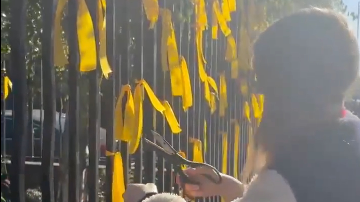 A video shows the moment a woman cut down memorial ribbons with scissors
