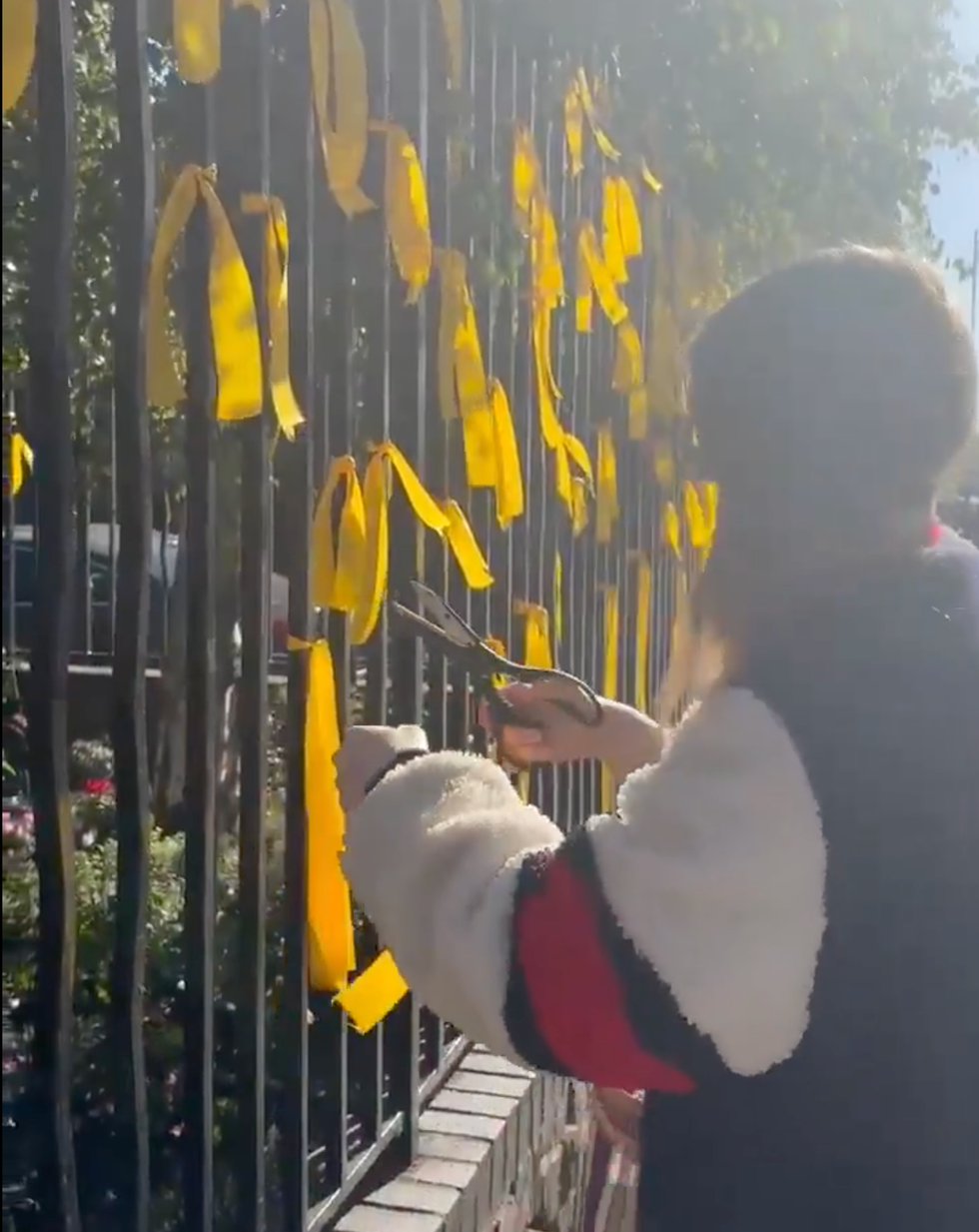 A video shows the moment a woman cut down memorial ribbons with scissors