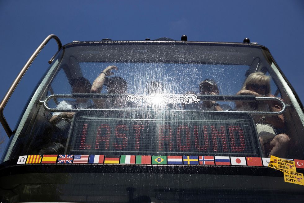 A view shows a wet tourist bus, as acitivists against tourism stop it by shooting with water pistol