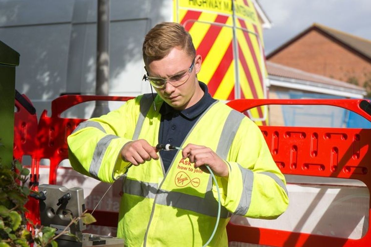 a virgin media engineer is pictured fitting broadband cables for its fibre broadband and landline service 