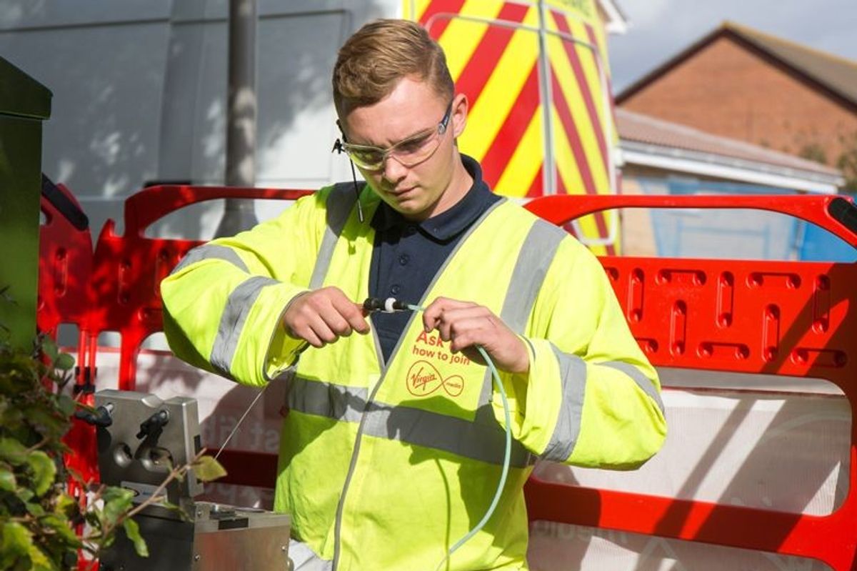 a virgin media engineer is pictured fitting broadband cables for its fibre broadband and landline service 