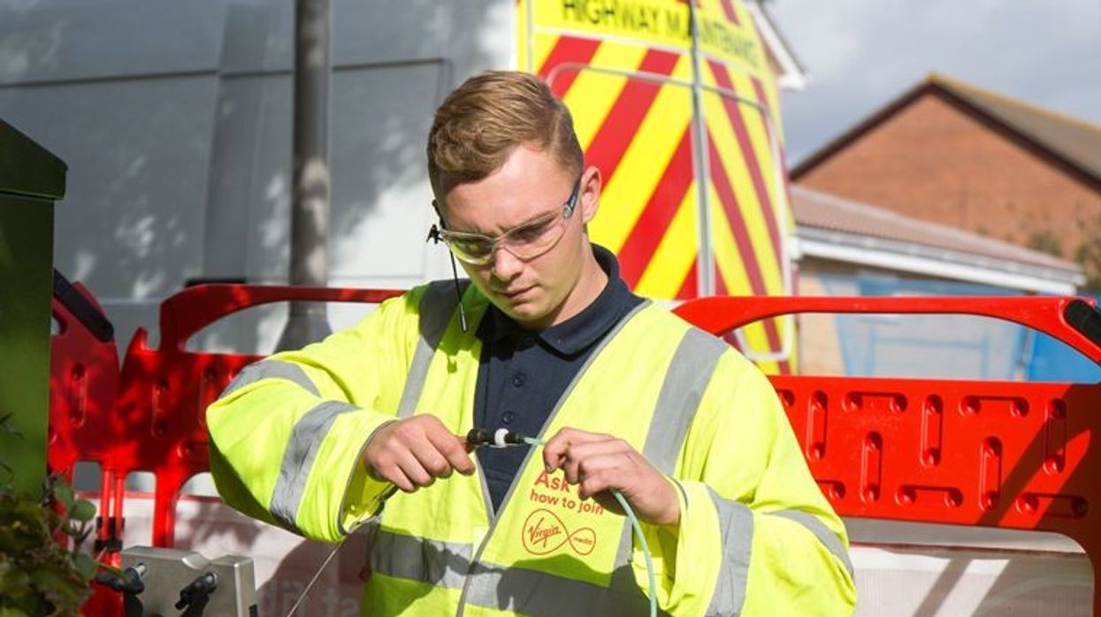a virgin media engineer is pictured fitting broadband cables for its fibre broadband and landline service