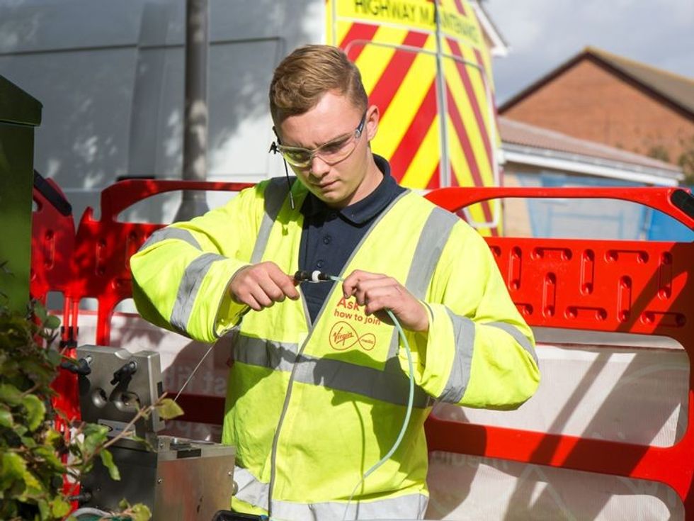 a virgin media engineer is pictured fitting broadband cables for its fibre broadband and landline service 