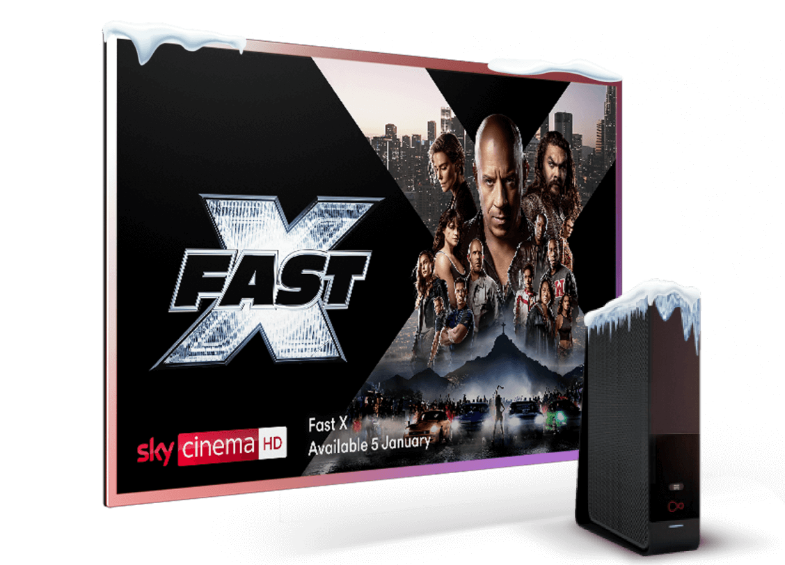 a virgin media router topped with snow sits in front of a flatscreen television with Sky Cinema on-screen