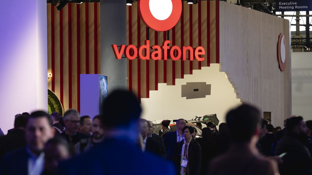a vodafone sign hangs above a crowd of people