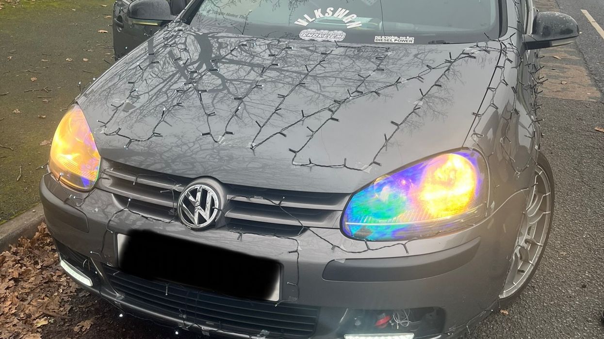 A Volkswagen with Christmas lights taped on the bonnet