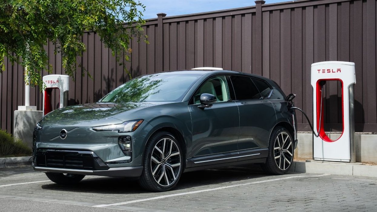 A Volvo electric car charging at a Tesla Supercharger