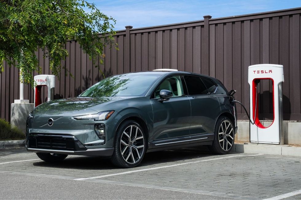 A Volvo electric car charging at a Tesla Supercharger