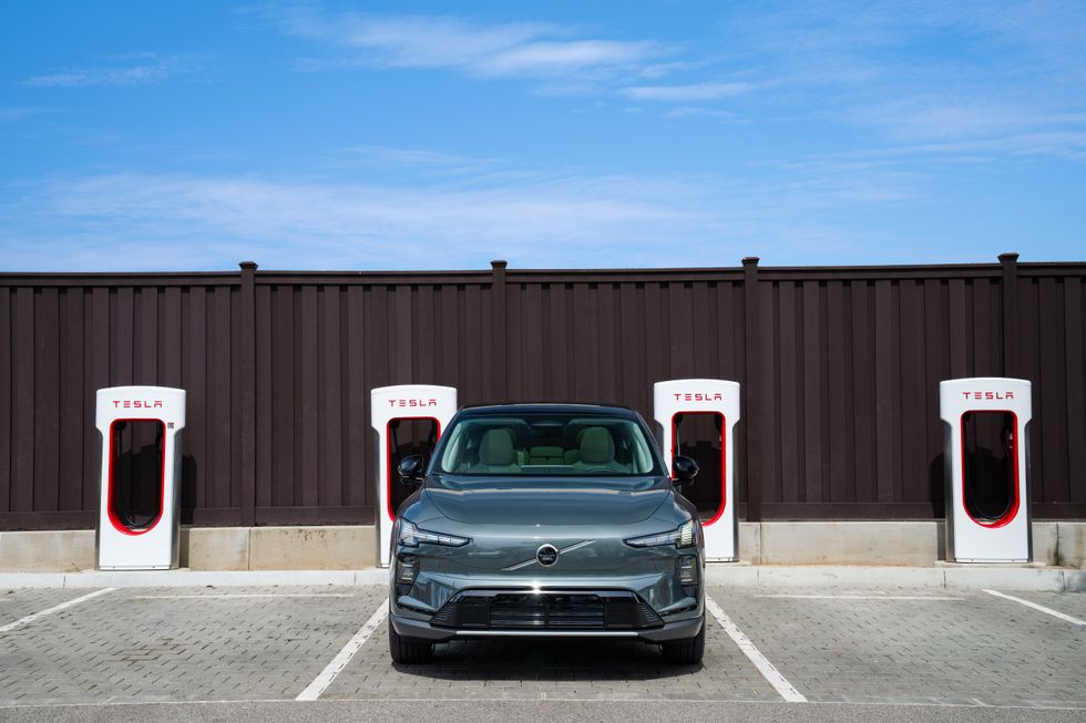 A Volvo electric car charging at a Tesla Supercharger