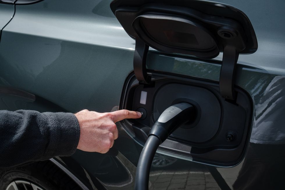A Volvo electric car charging at a Tesla Supercharger
