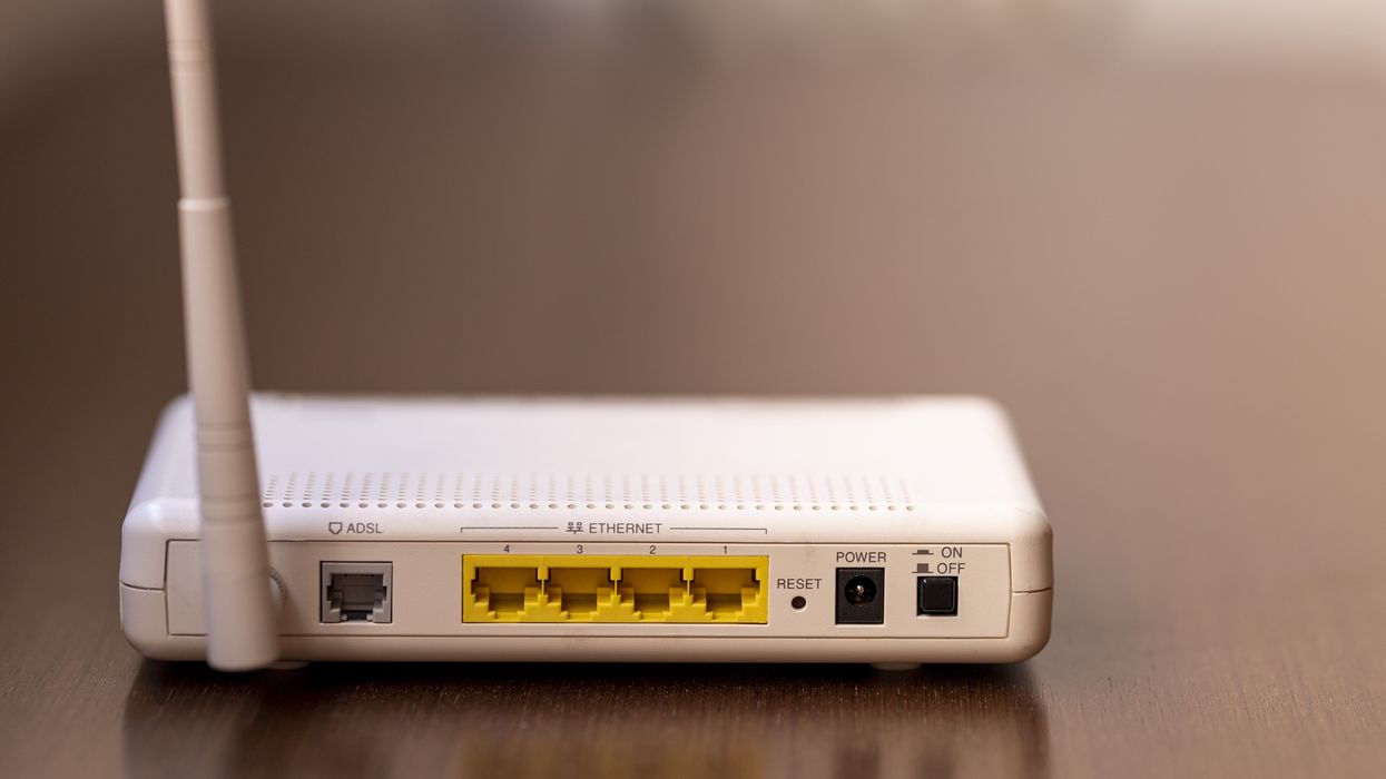a wi-fi router pictured on the floor with ethernet ports facing the camera