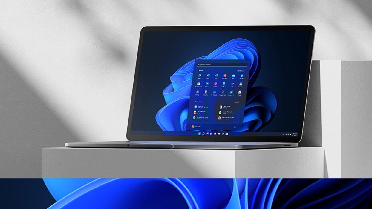 a windows 11 laptop with the start menu open sits on a pedestal