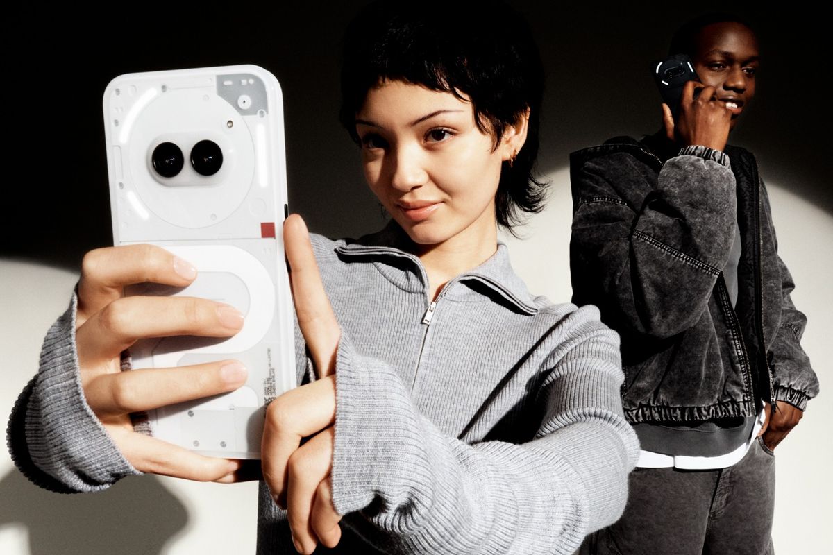 a woman and man wearing a grey sweatshirts holding nothing phone 2a in white and black colourways 