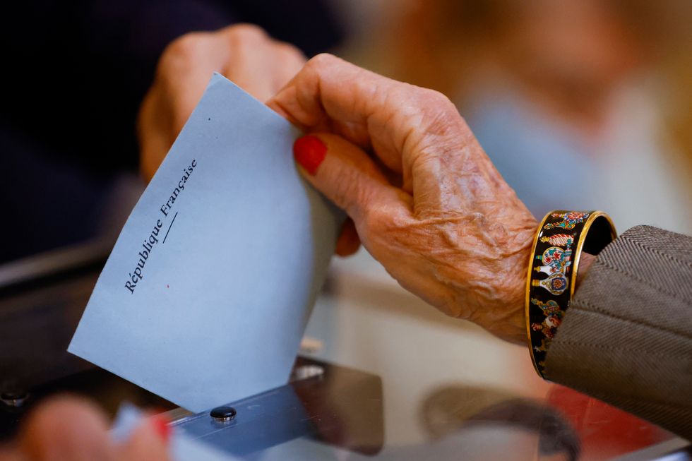 A woman casts her ballot in the second round of the 2022 French presidential election at a polling station in Lyon, France, April 24, 2022. REUTERS/Stephane Mahe