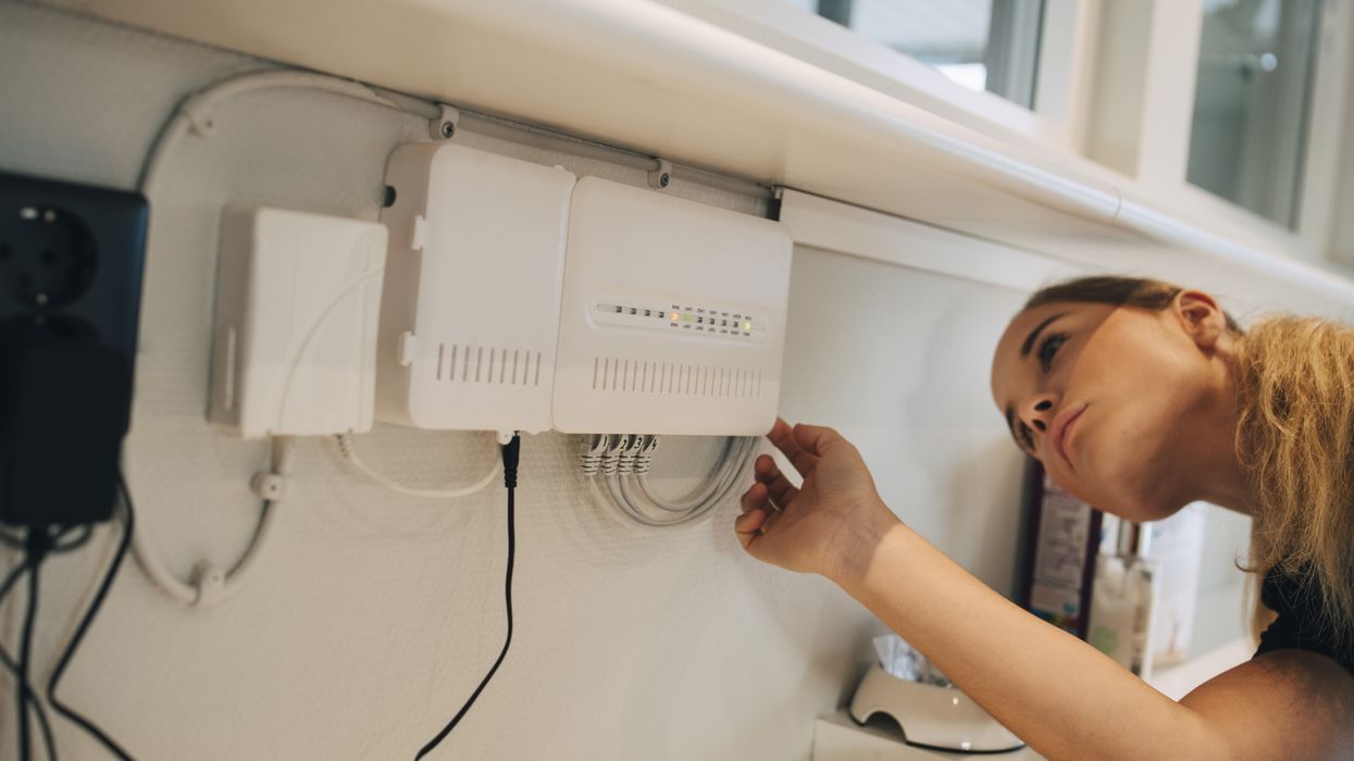 a woman check the ethernet cables connected to her wi-fi router