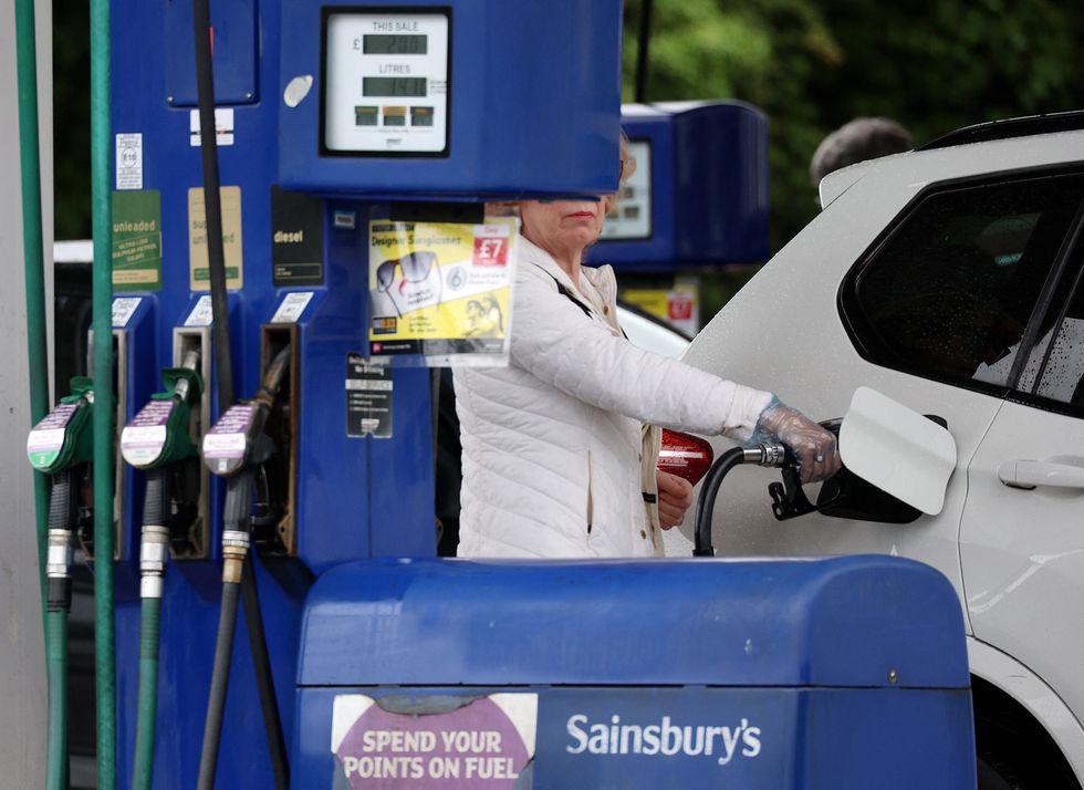 A woman filling her car up with fuel at a petrol station.
