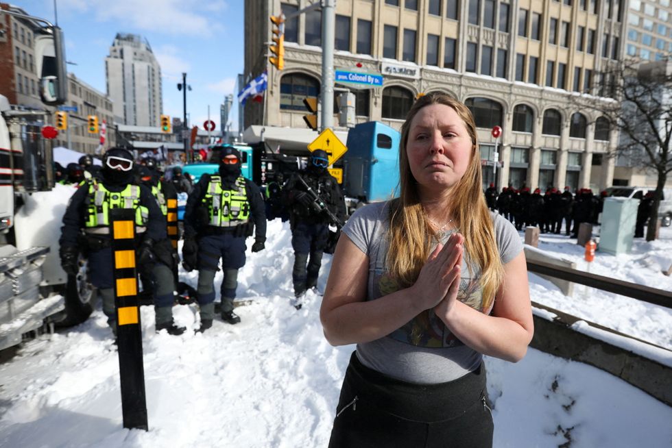 A woman folds her hands, as truckers and supporters continue to protest coronavirus disease (COVID-19) vaccine mandates, in Ottawa, Ontario, Canada.
