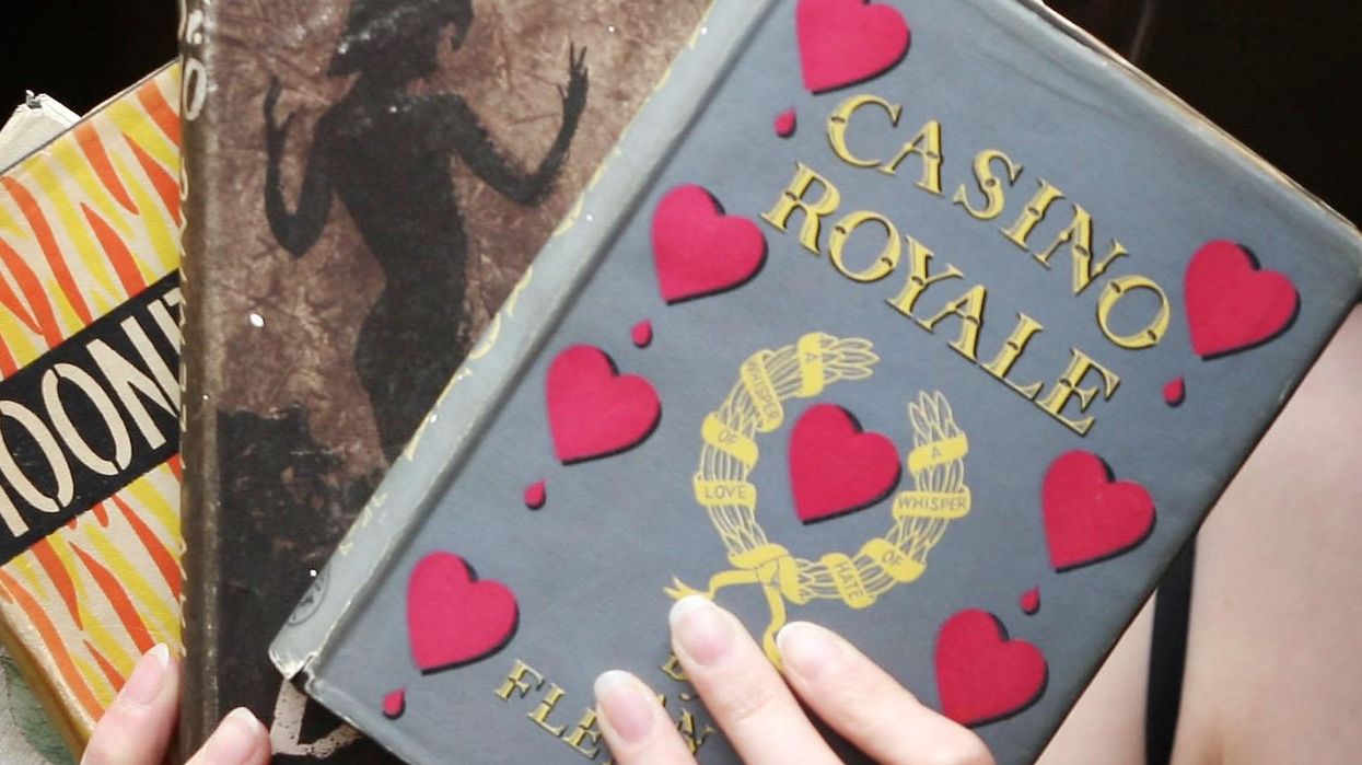 A woman holding copies of Ian Fleming's James Bond novels.