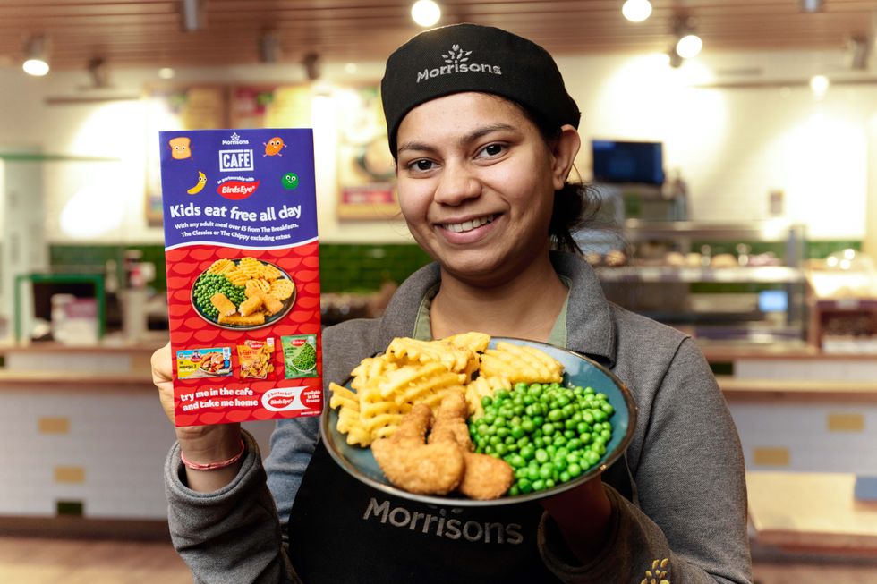 A woman holding up a sign advertising the "Kids eat free all day" scheme, as well as a plate of fries, chicken nuggets and peas