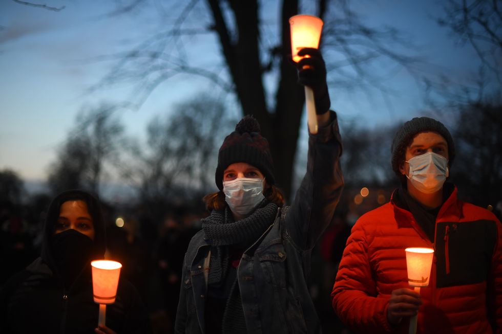 A woman holds a candle at a vigil for Sarah in 2021.