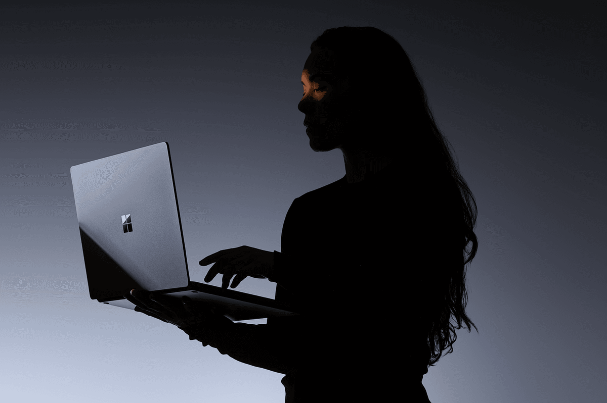 a woman holds a surface laptop