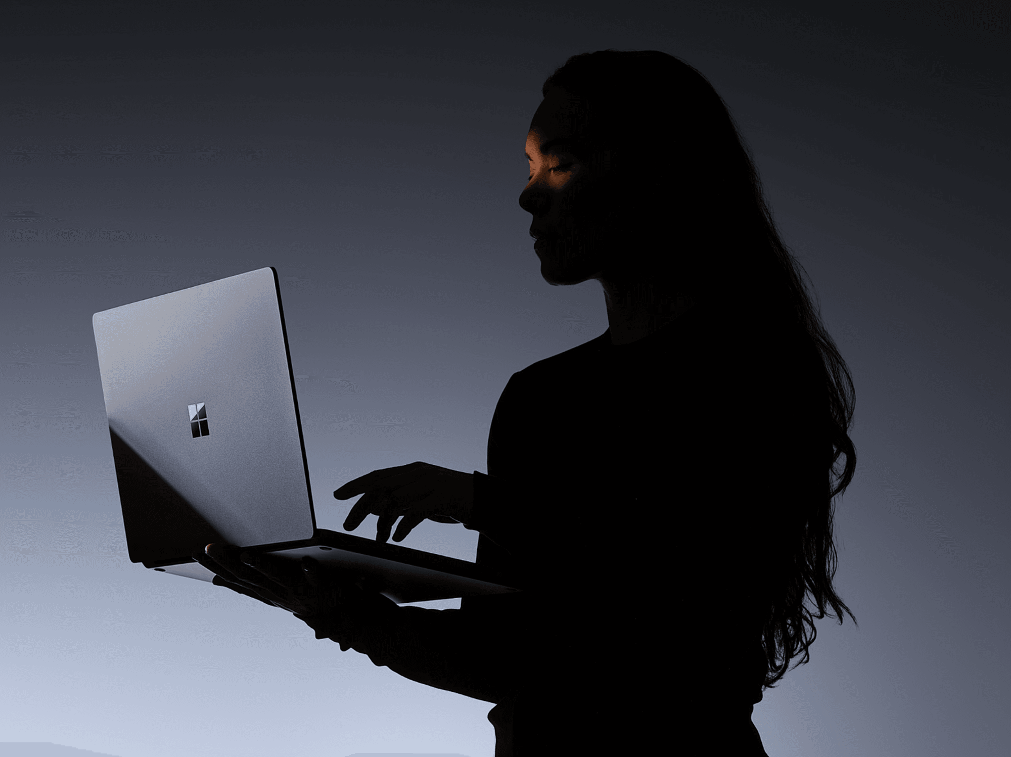 a woman holds a surface laptop