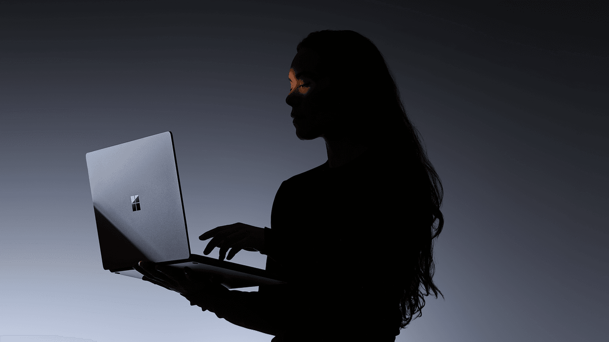 a woman holds a surface laptop